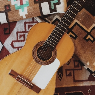 Guitar on patterned blankets Junior Pereira